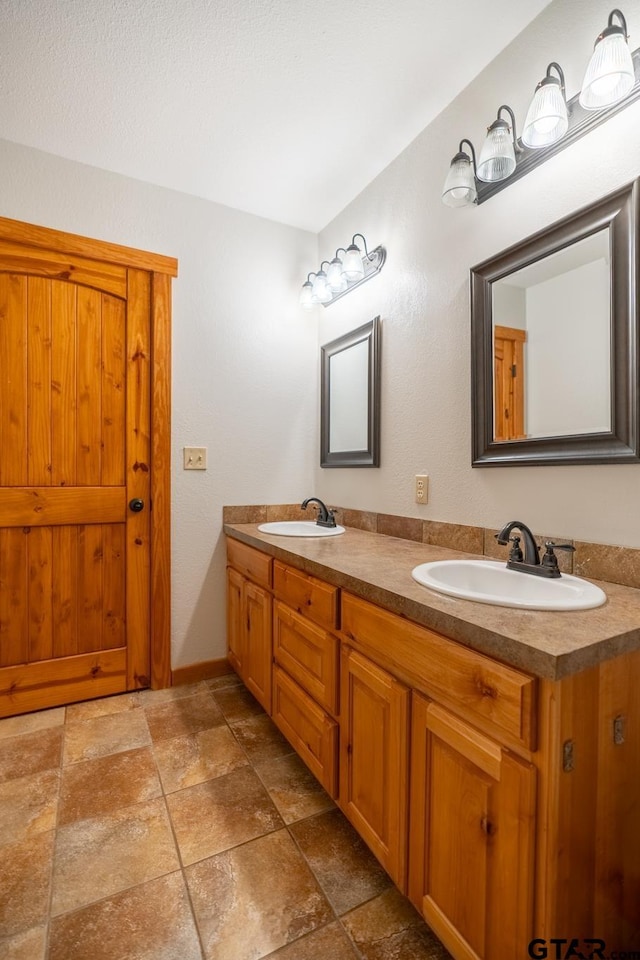 5646 Fm 346, Tyler, TX 75703 - full bathroom featuring stone finish floor, double vanity, a sink, and baseboards