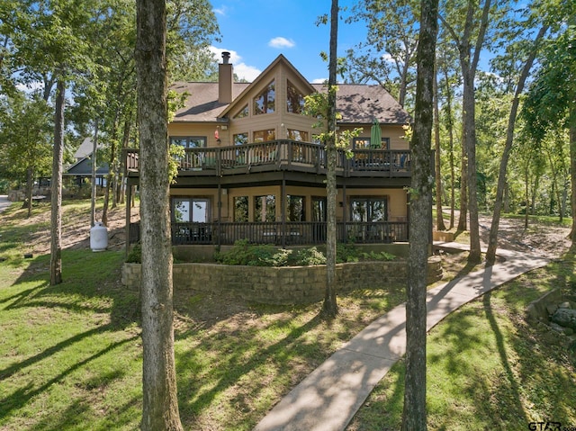 back of house featuring a lawn and a deck