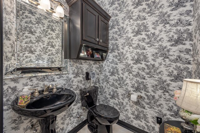 5875 Stonegate Trl, Tyler, TX 75703 - bathroom with toilet, baseboards, a sink, and wallpapered walls