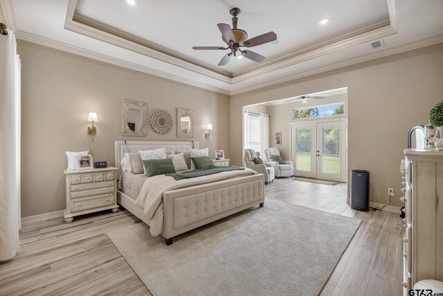 5875 Stonegate Trl, Tyler, TX 75703 - bedroom with a tray ceiling, access to exterior, crown molding, french doors, and light wood-style floors