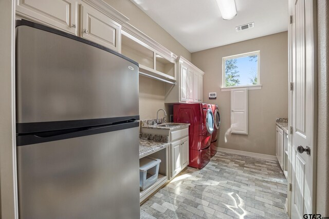 5875 Stonegate Trl, Tyler, TX 75703 - laundry area with brick flooring, washer and dryer, cabinet space, and baseboards