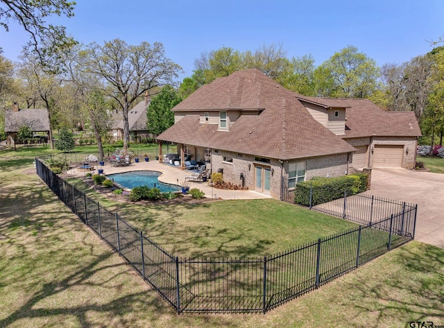 5875 Stonegate Trl, Tyler, TX 75703 - back of property featuring concrete driveway, brick siding, a patio area, and a shingled roof