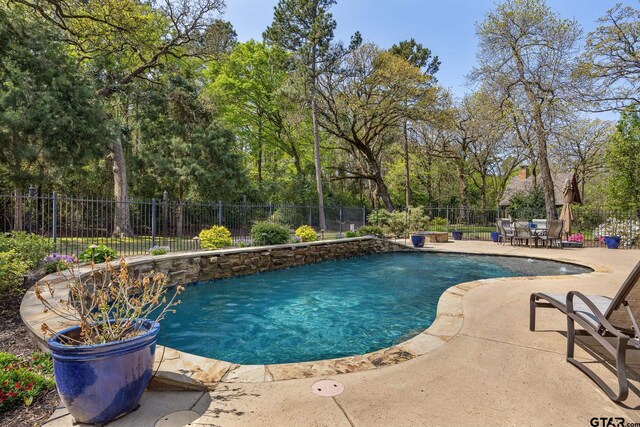 5875 Stonegate Trl, Tyler, TX 75703 - view of swimming pool with a patio, fence, and view of wooded area