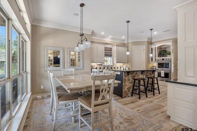 5875 Stonegate Trl, Tyler, TX 75703 - dining area with plenty of natural light, light wood-style flooring, ornamental molding, recessed lighting, and baseboards