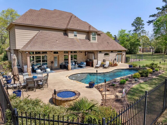 5875 Stonegate Trl, Tyler, TX 75703 - view of swimming pool featuring a patio, a fenced backyard, and an outdoor living space with a fire pit