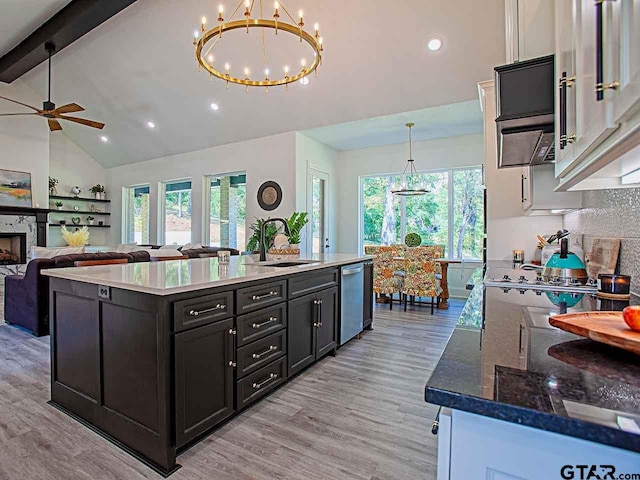 kitchen featuring sink, stainless steel dishwasher, pendant lighting, lofted ceiling with beams, and light wood-type flooring