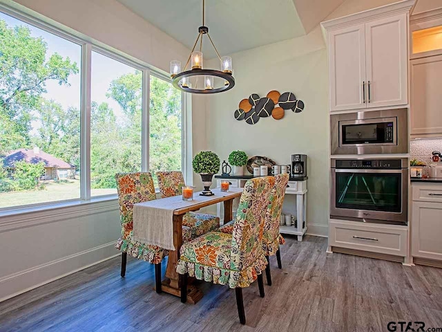 dining area featuring hardwood / wood-style floors, plenty of natural light, and a notable chandelier