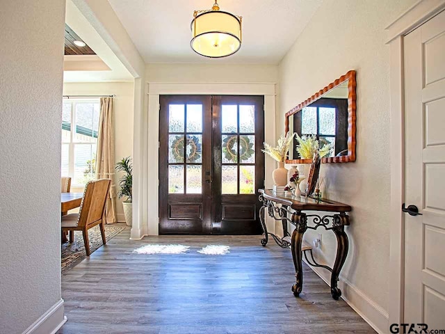 foyer with hardwood / wood-style floors and french doors