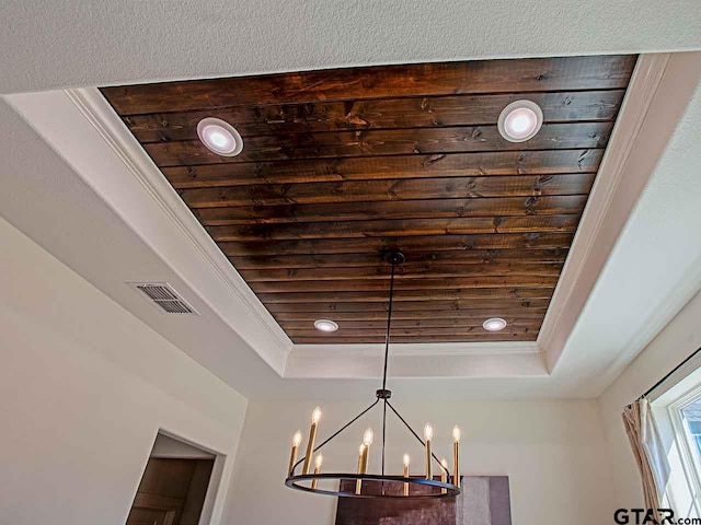 room details featuring a notable chandelier, crown molding, and a raised ceiling