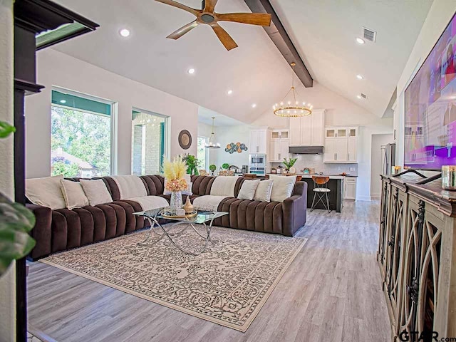 living room with high vaulted ceiling, beamed ceiling, light hardwood / wood-style floors, and ceiling fan with notable chandelier