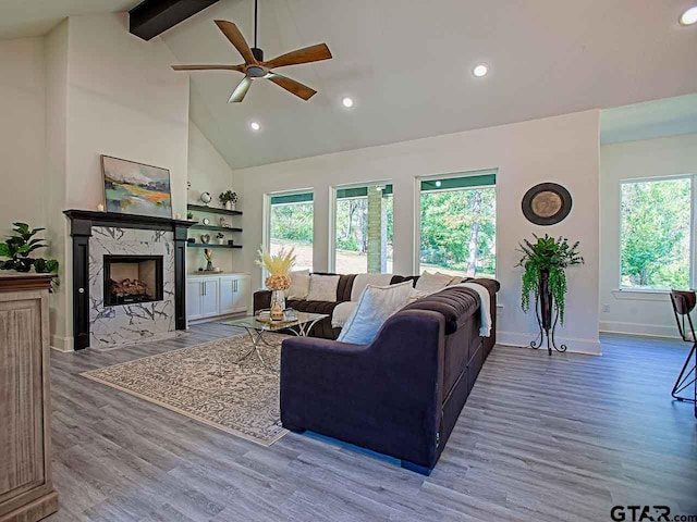 living room with high vaulted ceiling, beamed ceiling, hardwood / wood-style floors, and a premium fireplace