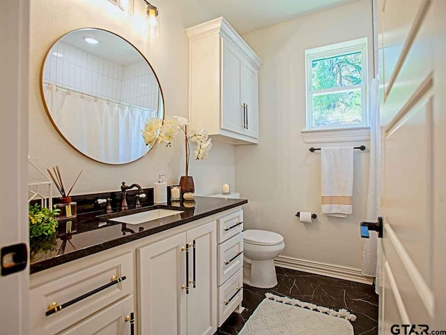 bathroom with curtained shower, vanity, and toilet