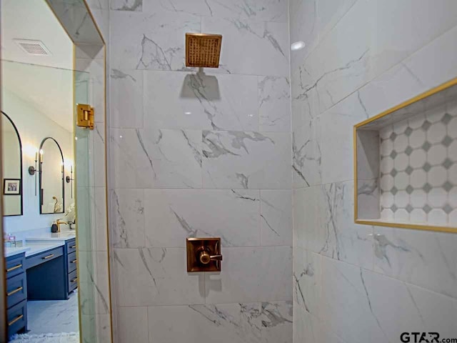 bathroom with vanity and tiled shower