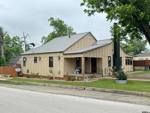 view of front of home featuring covered porch and a front lawn