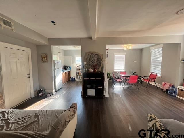 living room featuring beamed ceiling and dark hardwood / wood-style floors