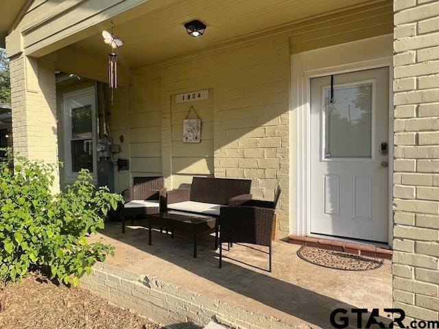 entrance to property with a patio and an outdoor living space