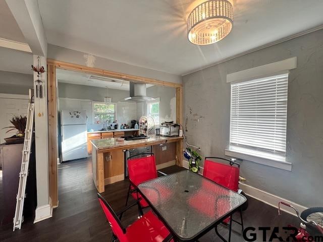 kitchen with sink, kitchen peninsula, wall chimney exhaust hood, dark wood-type flooring, and white fridge