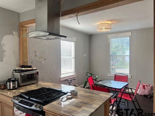 kitchen featuring extractor fan, black gas stove, and light brown cabinets