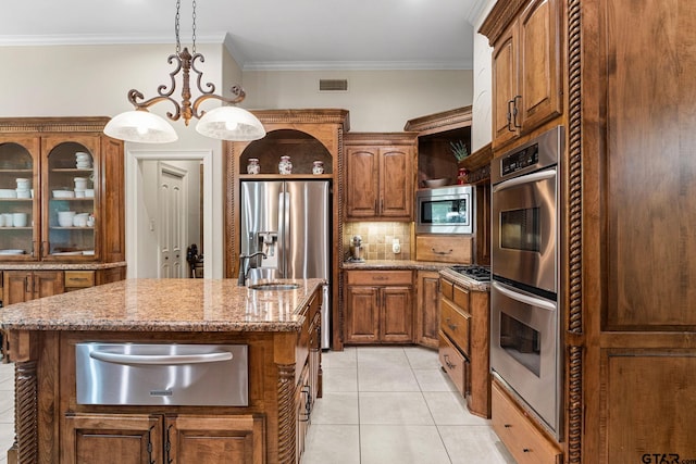 1516 Chaparrel Run, Tyler, TX 75703 - kitchen with a warming drawer, appliances with stainless steel finishes, an island with sink, decorative backsplash, and brown cabinetry