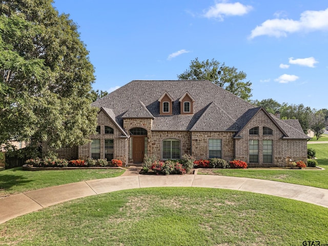 1516 Chaparrel Run, Tyler, TX 75703 - french country inspired facade with a front lawn, brick siding, and roof with shingles