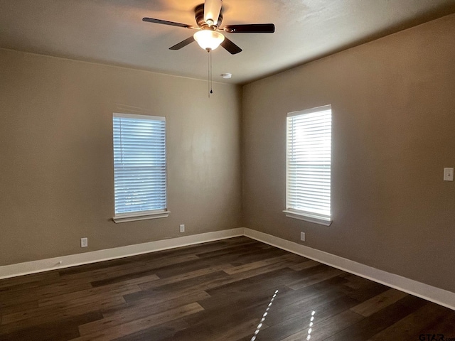 spare room with ceiling fan and dark wood-type flooring