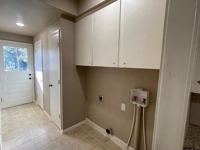 clothes washing area with hookup for an electric dryer, cabinets, light tile patterned floors, and hookup for a washing machine