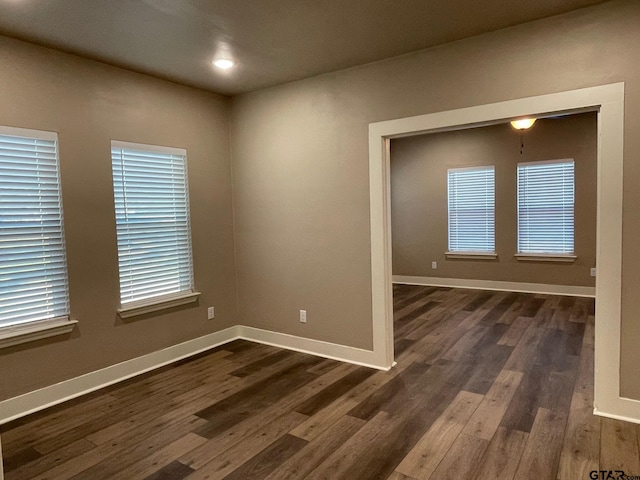 spare room with plenty of natural light and dark wood-type flooring