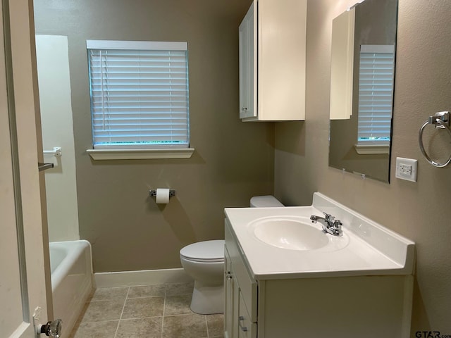 bathroom featuring tile patterned floors, a bathtub, vanity, and toilet