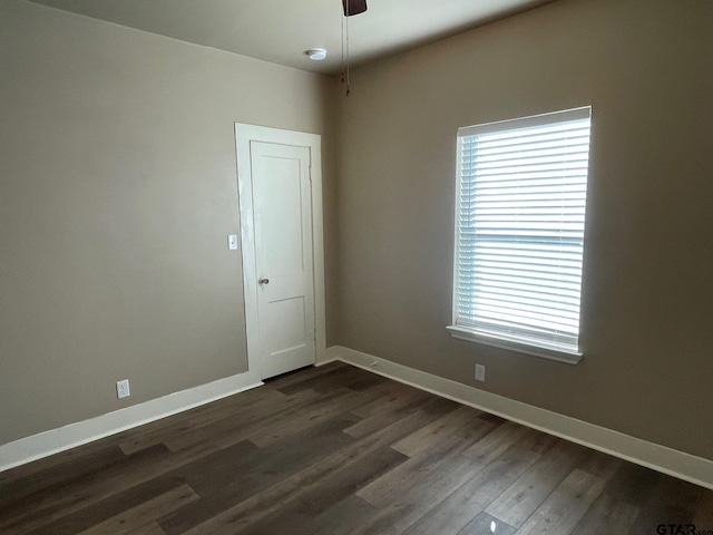 spare room with ceiling fan and dark wood-type flooring