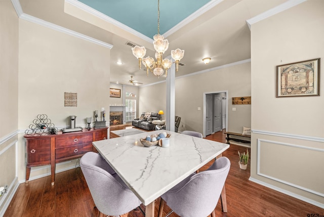 1408 Santa Fe Trl, Tyler, TX 75703 - dining space with ceiling fan, a lit fireplace, crown molding, dark wood finished floors, and a chandelier