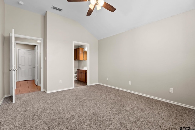 unfurnished bedroom with ceiling fan, light colored carpet, connected bathroom, and vaulted ceiling