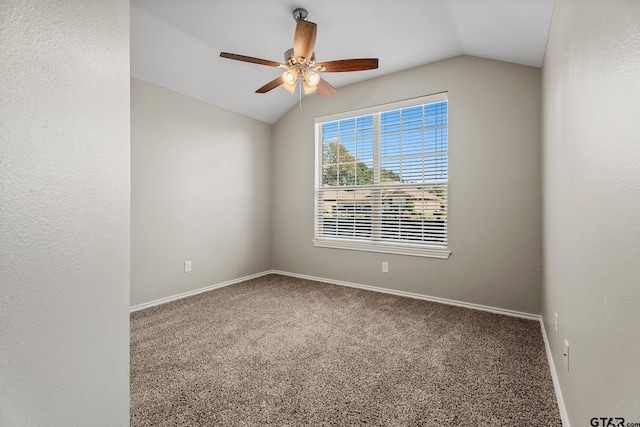 empty room with ceiling fan, carpet floors, and vaulted ceiling