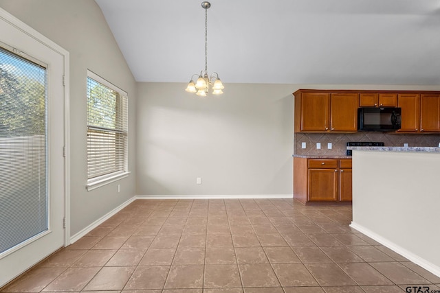 kitchen featuring pendant lighting, lofted ceiling, backsplash, a notable chandelier, and light tile patterned flooring