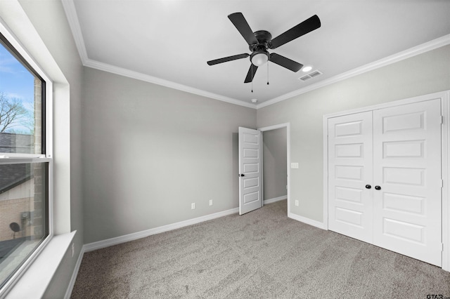 unfurnished bedroom featuring ceiling fan, a closet, carpet floors, and ornamental molding