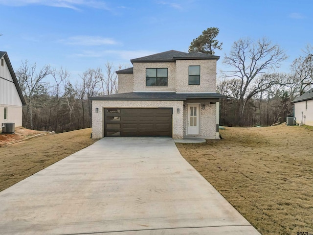 view of front of property with a garage, a front yard, and central AC