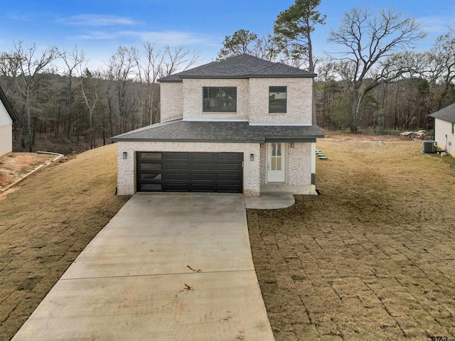 view of front of home featuring central AC unit and a garage