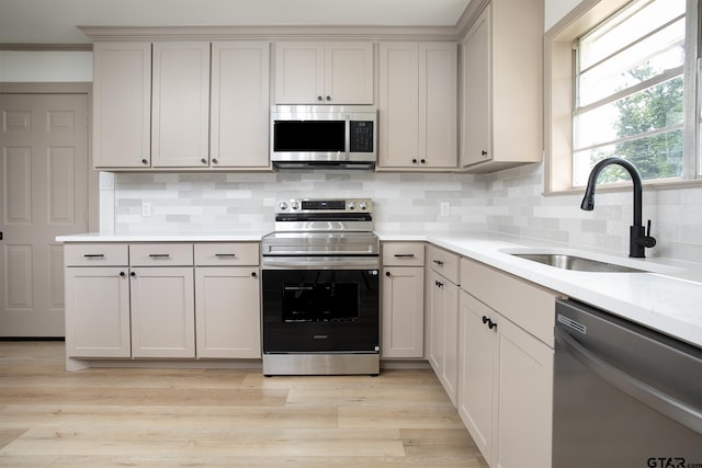 914 Neches Dr, Tyler, TX 75702 - kitchen with stainless steel appliances, light countertops, tasteful backsplash, and light wood-style floors