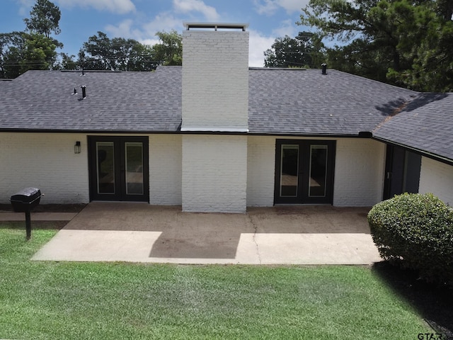 914 Neches Dr, Tyler, TX 75702 - rear view of house with french doors, a shingled roof, a chimney, a lawn, and brick siding