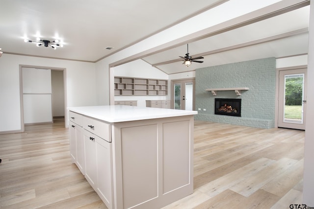 914 Neches Dr, Tyler, TX 75702 - kitchen featuring a center island, light countertops, a fireplace, and light wood finished floors