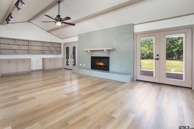 914 Neches Dr, Tyler, TX 75702 - unfurnished living room with french doors, light wood-style flooring, a ceiling fan, and a brick fireplace