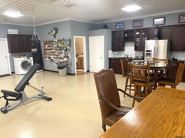 kitchen featuring sink, stainless steel refrigerator with ice dispenser, backsplash, washer / clothes dryer, and dark brown cabinets