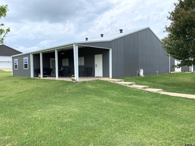 rear view of property featuring an outbuilding and a yard