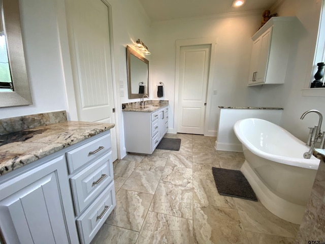 bathroom with a tub to relax in, vanity, and ornamental molding