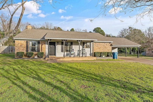 ranch-style house with a carport, covered porch, and a front yard