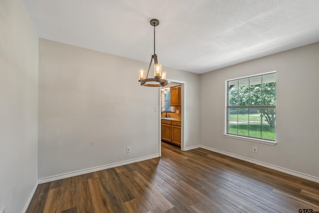 169 Phil Dr, Hawkins, TX 75765 - empty room featuring dark wood finished floors and a chandelier