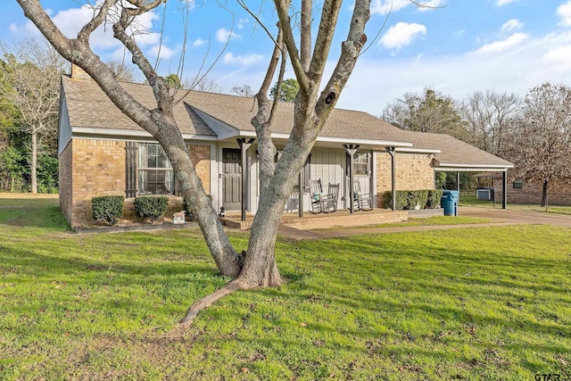 ranch-style home featuring a front lawn, a carport, and covered porch