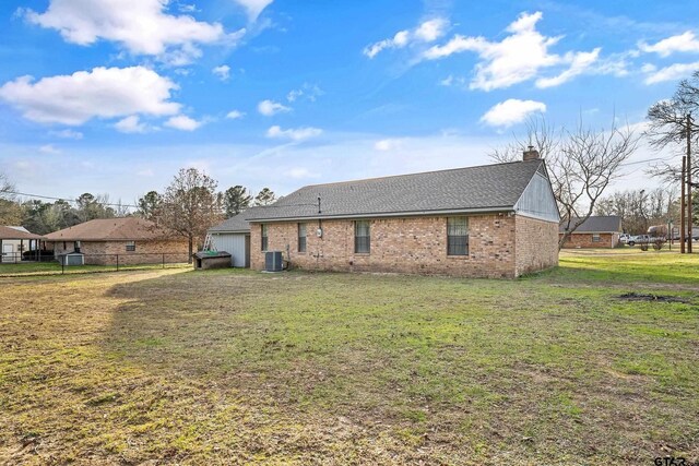 169 Phil Dr, Hawkins, TX 75765 - rear view of house featuring a chimney, a garage, brick siding, and a shingled roof
