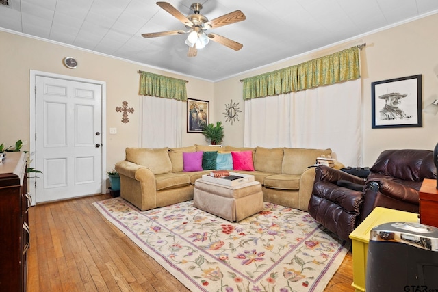 living room with light hardwood / wood-style flooring, ceiling fan, and ornamental molding