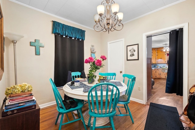 dining room with hardwood / wood-style floors, ornamental molding, and a chandelier