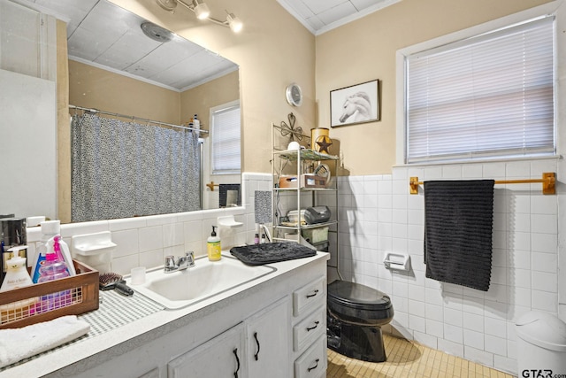 bathroom featuring tile patterned floors, vanity, crown molding, tile walls, and toilet